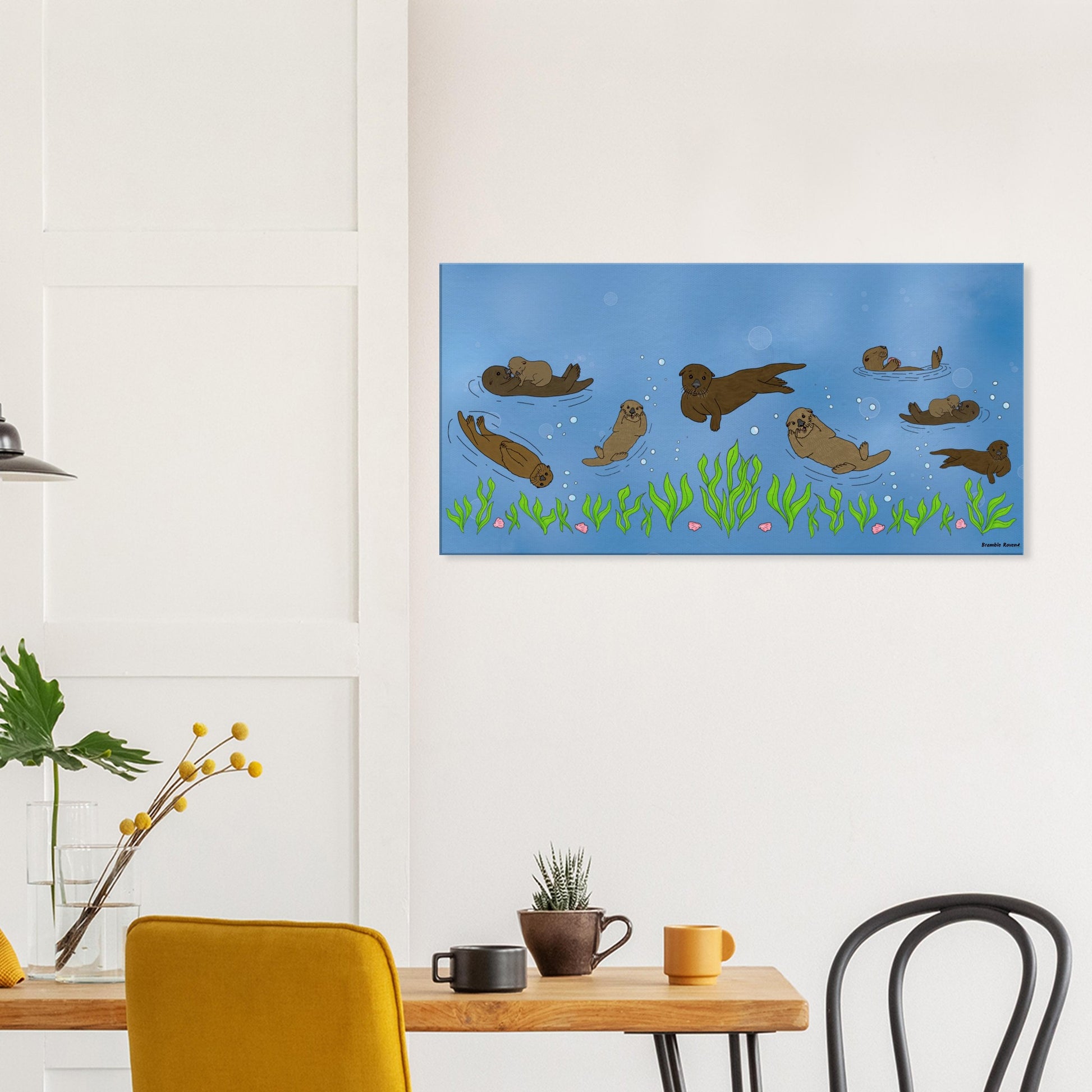 20 by 40 inch slim canvas wall art print of sea otters swimming along the seabed. Shown on wall above wooden kitchen table, cups and chairs.
