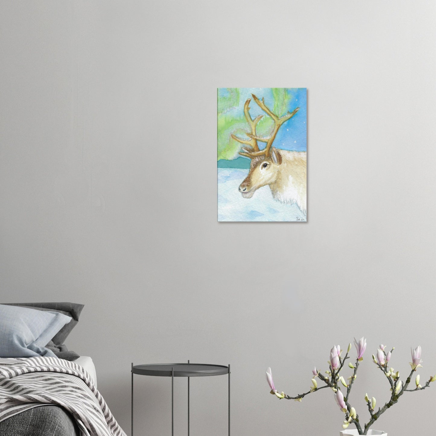 16 by 24 inch slim canvas print of Heather Silver's watercolor painting, northern lights reindeer. Shown on wall above grey bed, grey nightstand, and blooming branch décor.