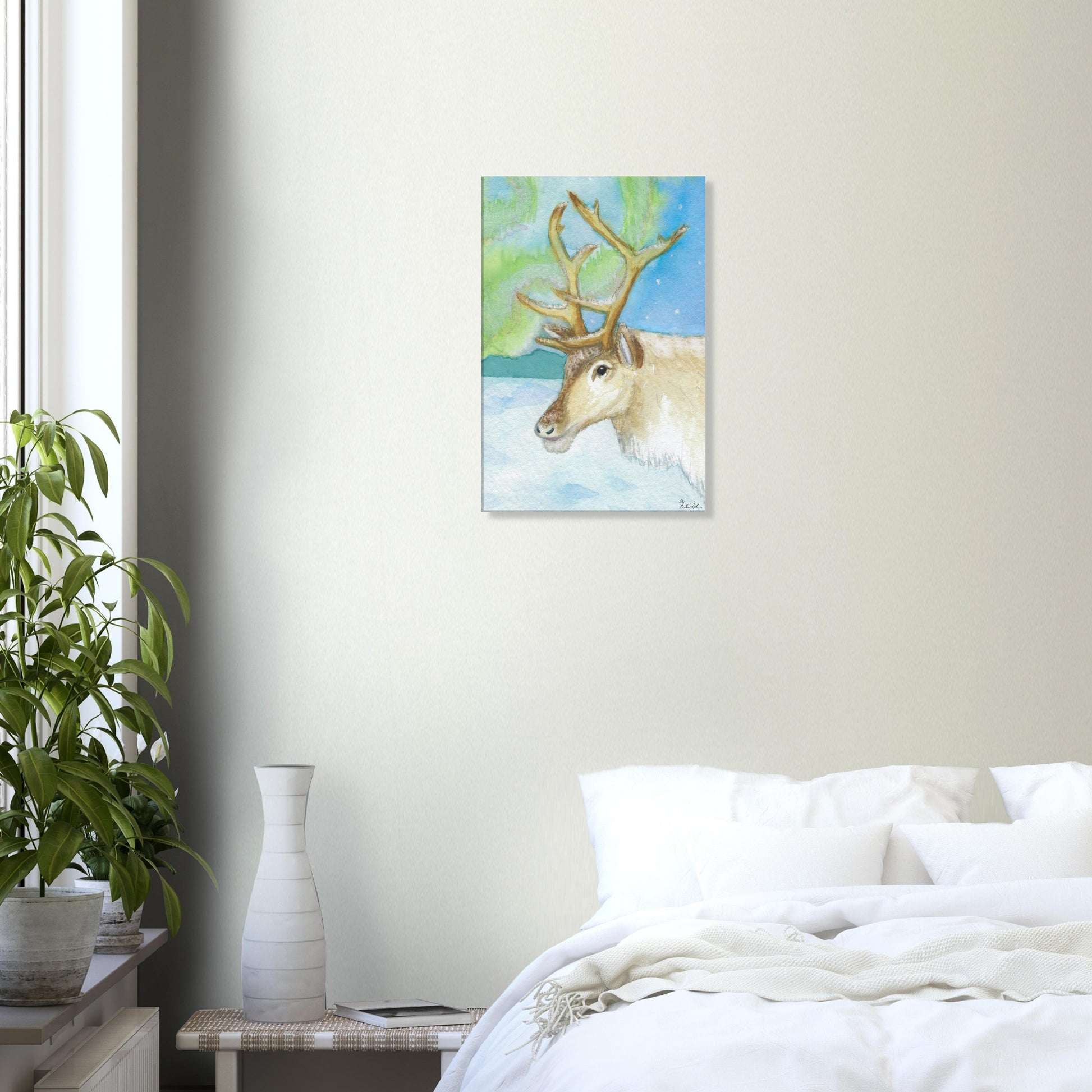 16 by 24 inch slim canvas print of Heather Silver's watercolor painting, northern lights reindeer. Shown on wall above white bed and nightstand.