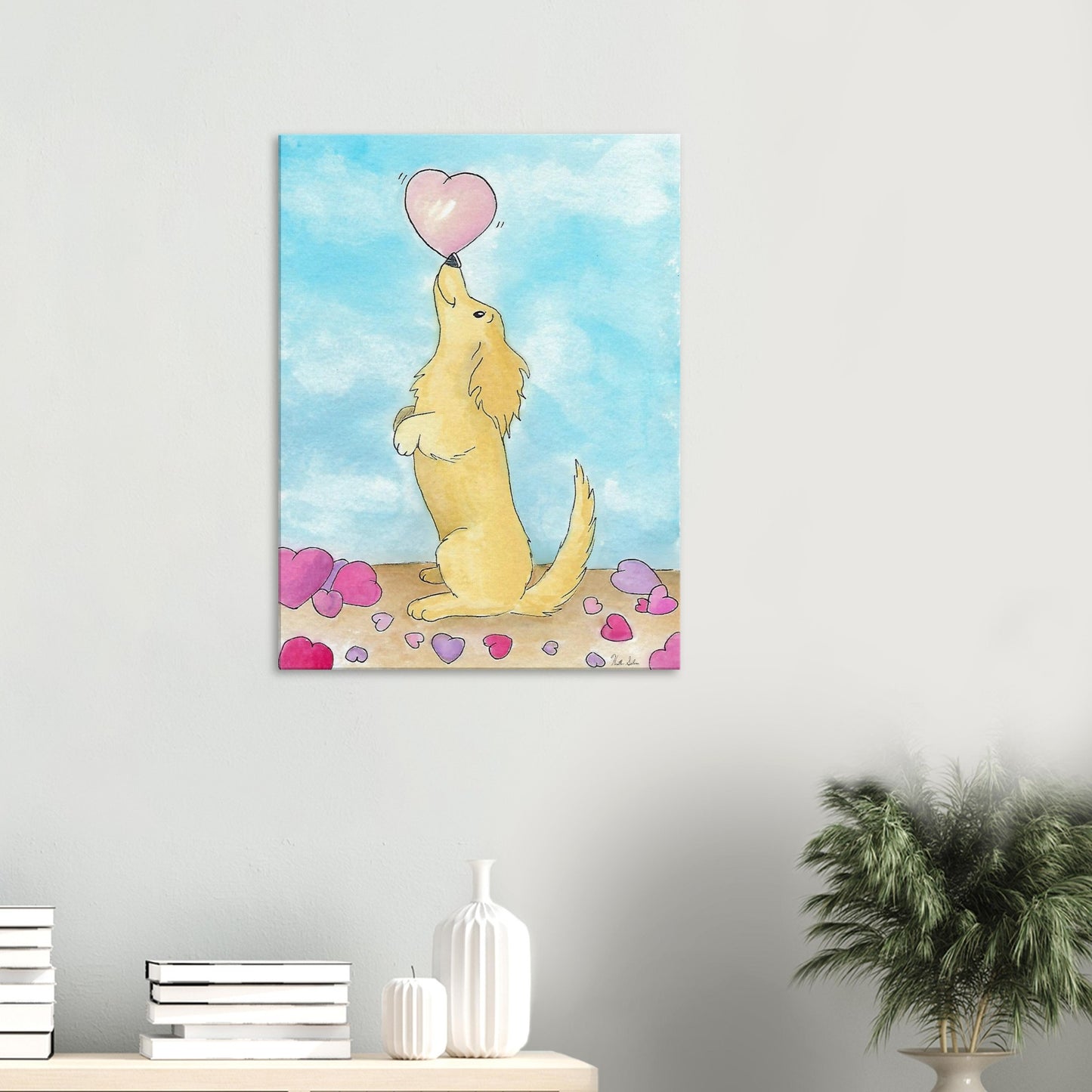 24 by 32 inch canvas wall art print of Heather Silver's watercolor painting, Puppy Love. It features a cute dog balancing a pink heart on its nose against a blue sky background. Canvas shown on wall above dresser with books and a potted plant.