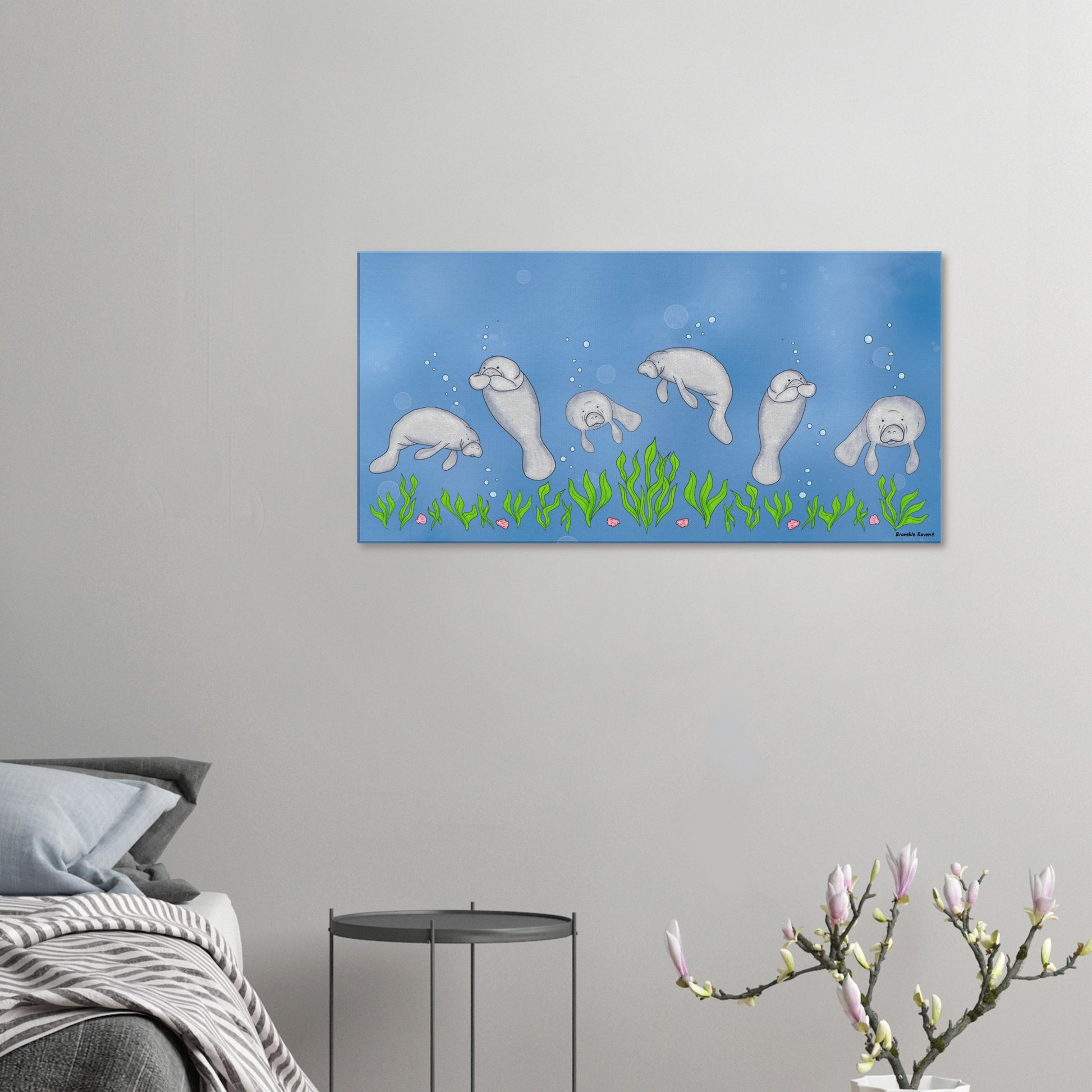 20 by 40 inch slim canvas wall art print featuring cute illustrated manatees swimming above the seabed. Shown on wall in bedroom above grey bed, grey nightstand, and blossoming plant decor.