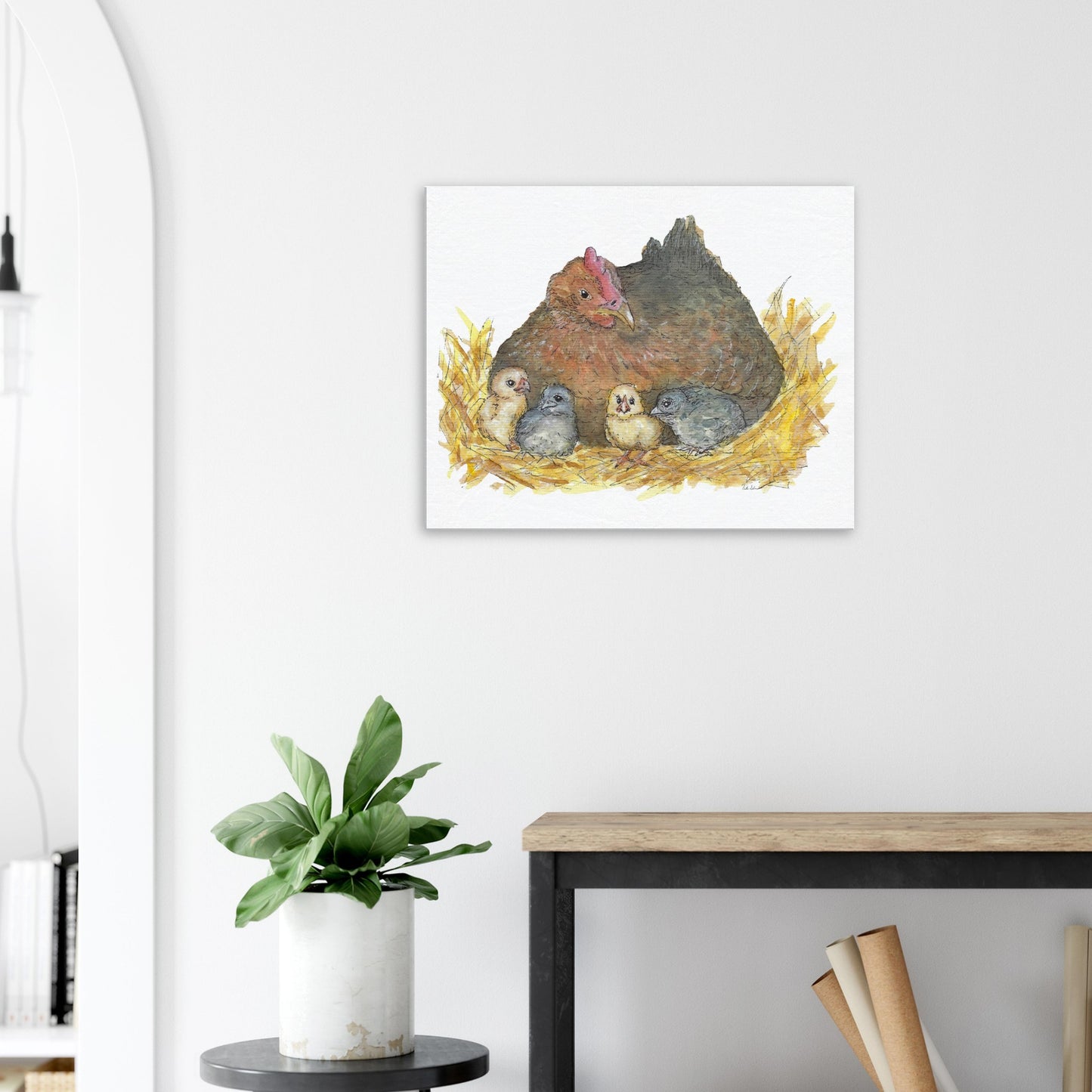 24 by 30 inch slim canvas Mother Hen print. Features a watercolor mother hen and her four chicks in a nest. Shown on wall above wooden side table.