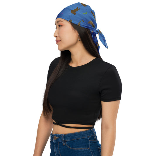 Large bandana with sea otters on a blue background. Shown on head of female model looking left.