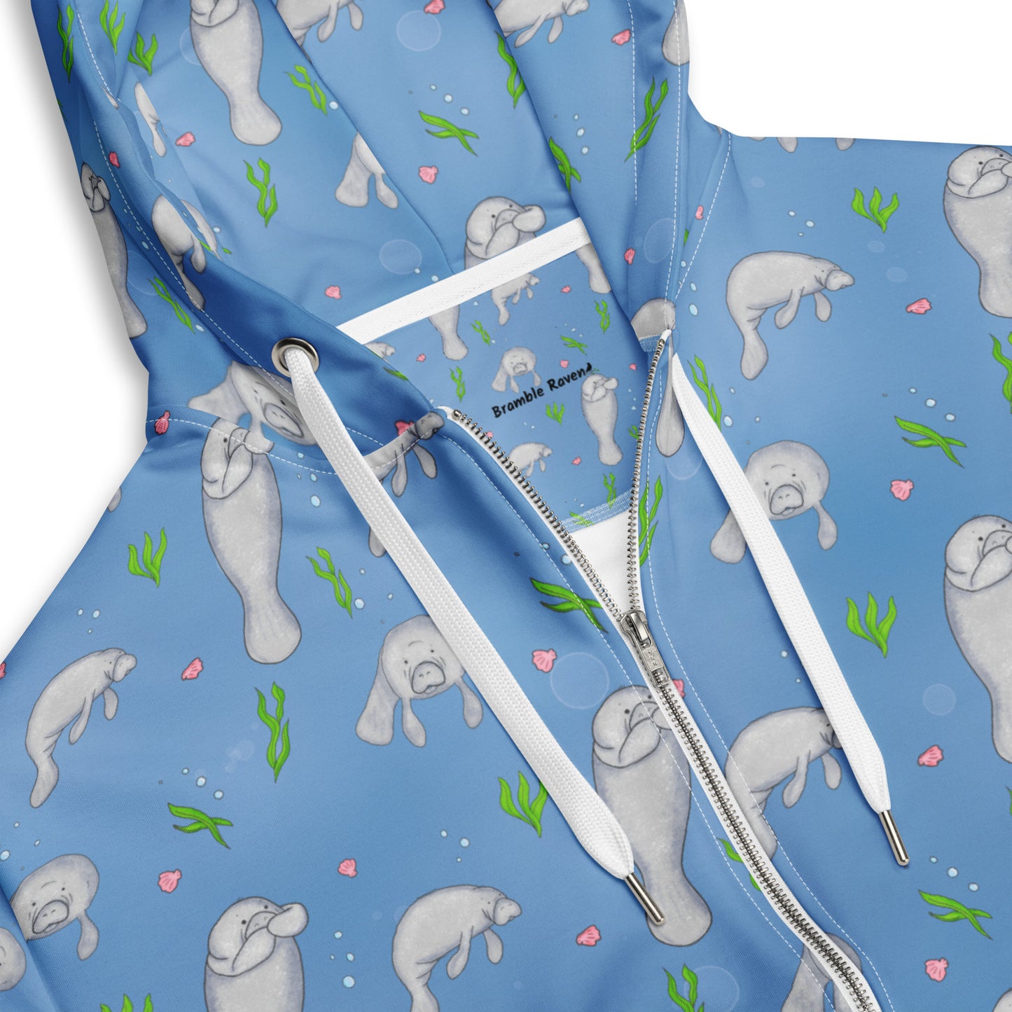 Unisex patterned manatee zip up hoodie. Made with recycled polyester. Soft cotton-feel outside fabric and fleece inside. Metal zipper, eyelets, and drawcord tips. Detail view of drawcords and zipper.
