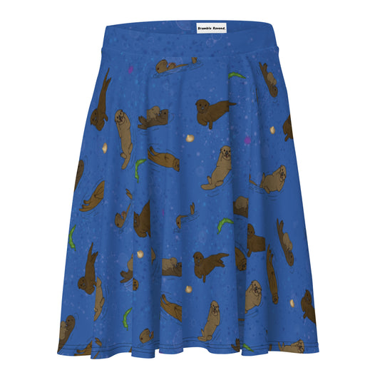 Skater skirt with pattern of hand illustrated sea otters surrounded by accents of sea urchins, seaweed, and shells on an ocean blue background.