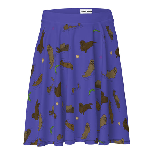 Skater skirt with pattern of hand illustrated sea otters surrounded by accents of sea urchins, seaweed, and shells on a purple background.