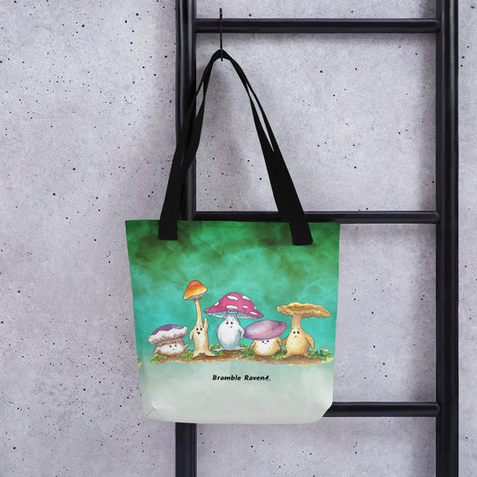 15 by 15 inch sturdy tote bag. Features Mushy and his whimsical mushroom friends on a green gradient background. Made of spun polyester with black cotton bull denim handles. Shown hanging from ladder.