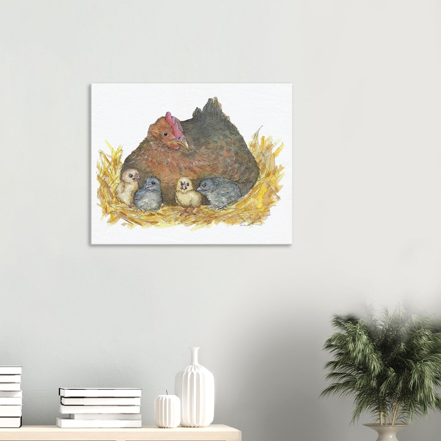 24 by 30 inch slim canvas Mother Hen print. Features a watercolor mother hen and her four chicks in a nest. Shown on wall above shelf with books and a potted plant.
