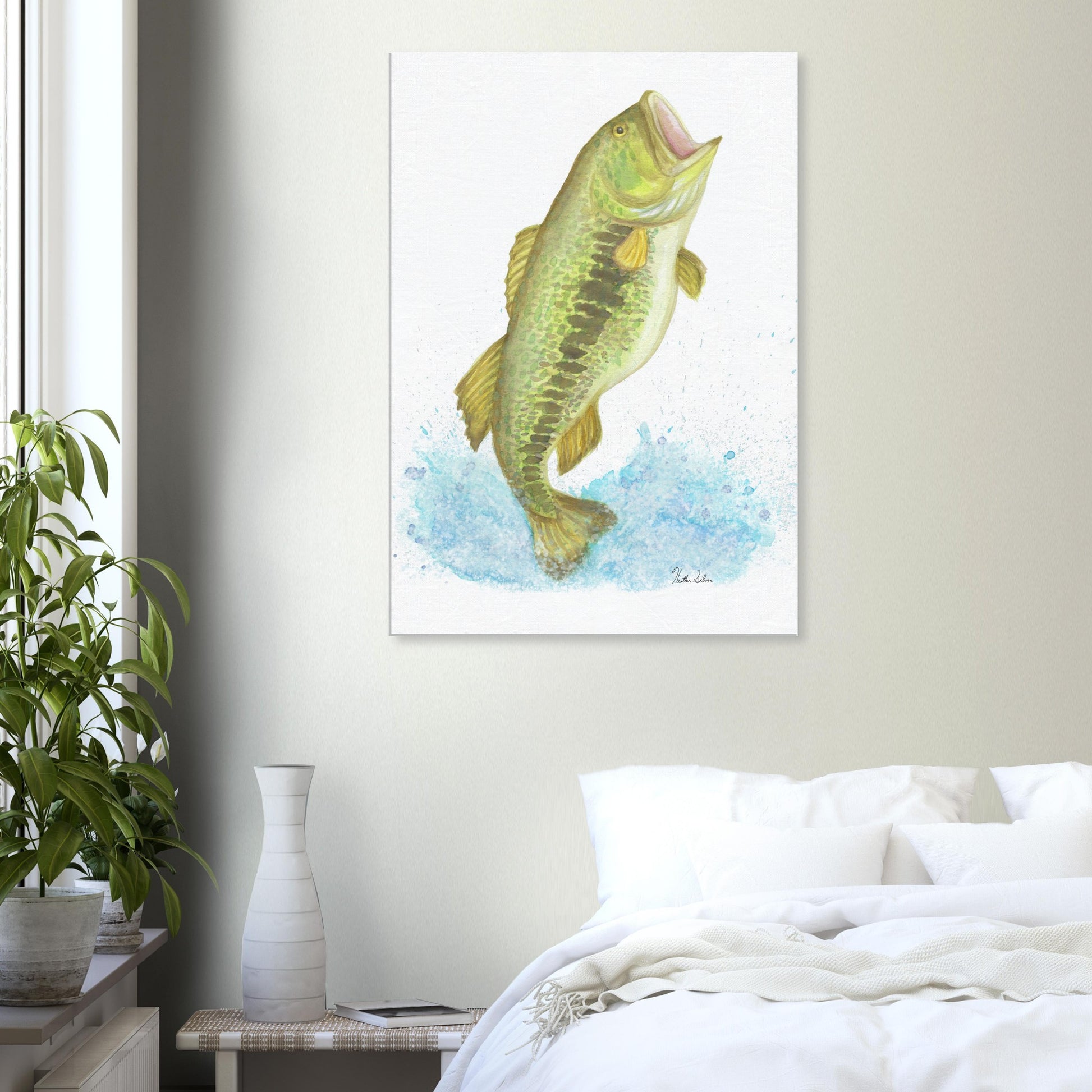 28 by 40 inch slim canvas wall art print featuring a watercolor painting of a largemouth bass leaping from the water. Shown on wall above white bed, nightstand, and potted plant.