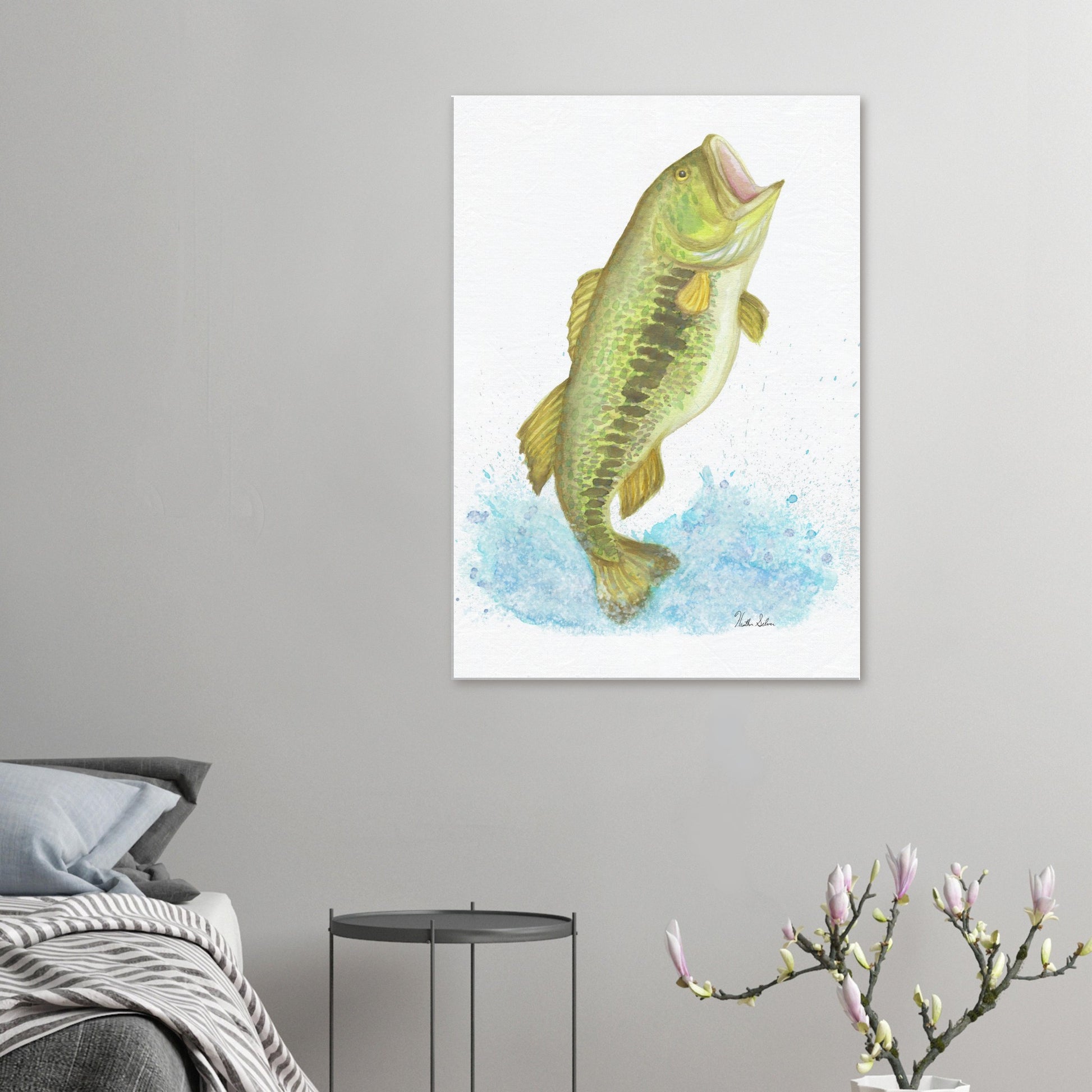 28 by 40 inch slim canvas wall art print featuring a watercolor painting of a largemouth bass leaping from the water. Shown above grey bed, grey nightstand, and flowering branch decor.