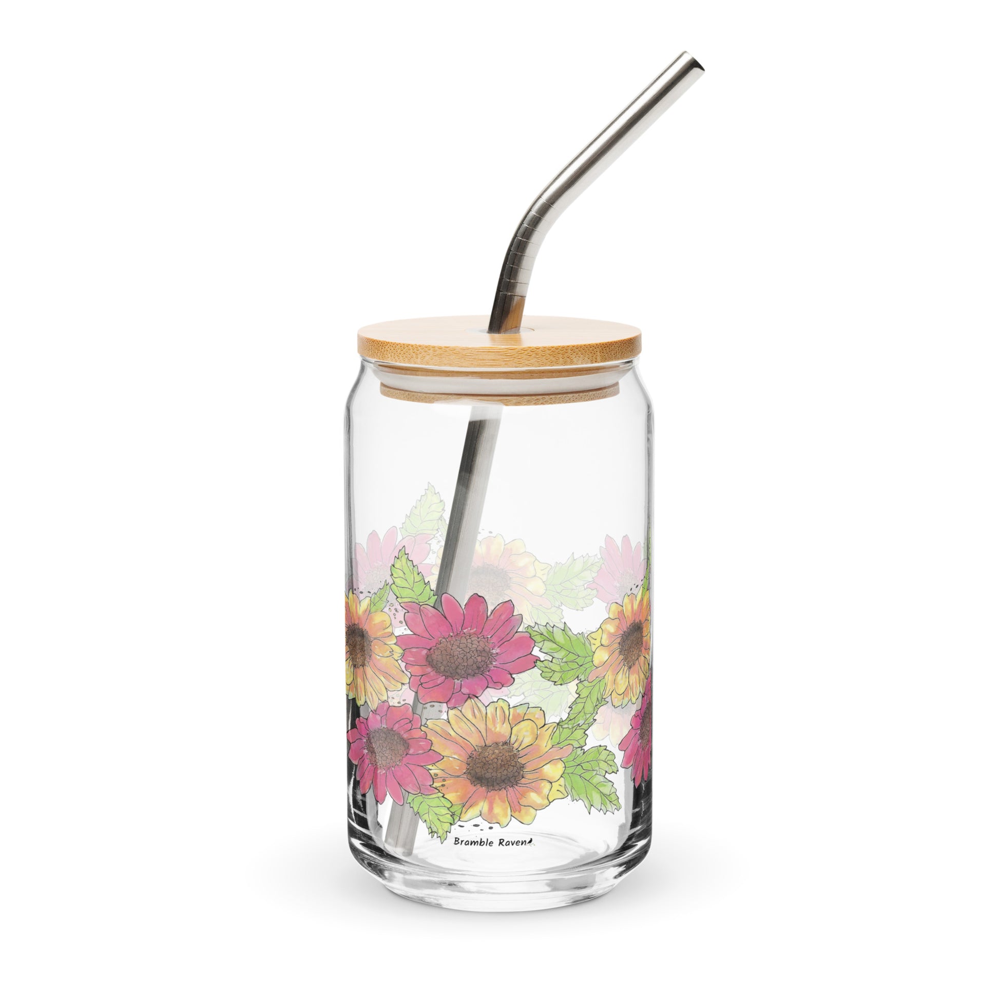 16 ounce can-shaped glass. Features wraparound print of watercolor Gerber daisies. Shown with bamboo lid and stainless steel straw.