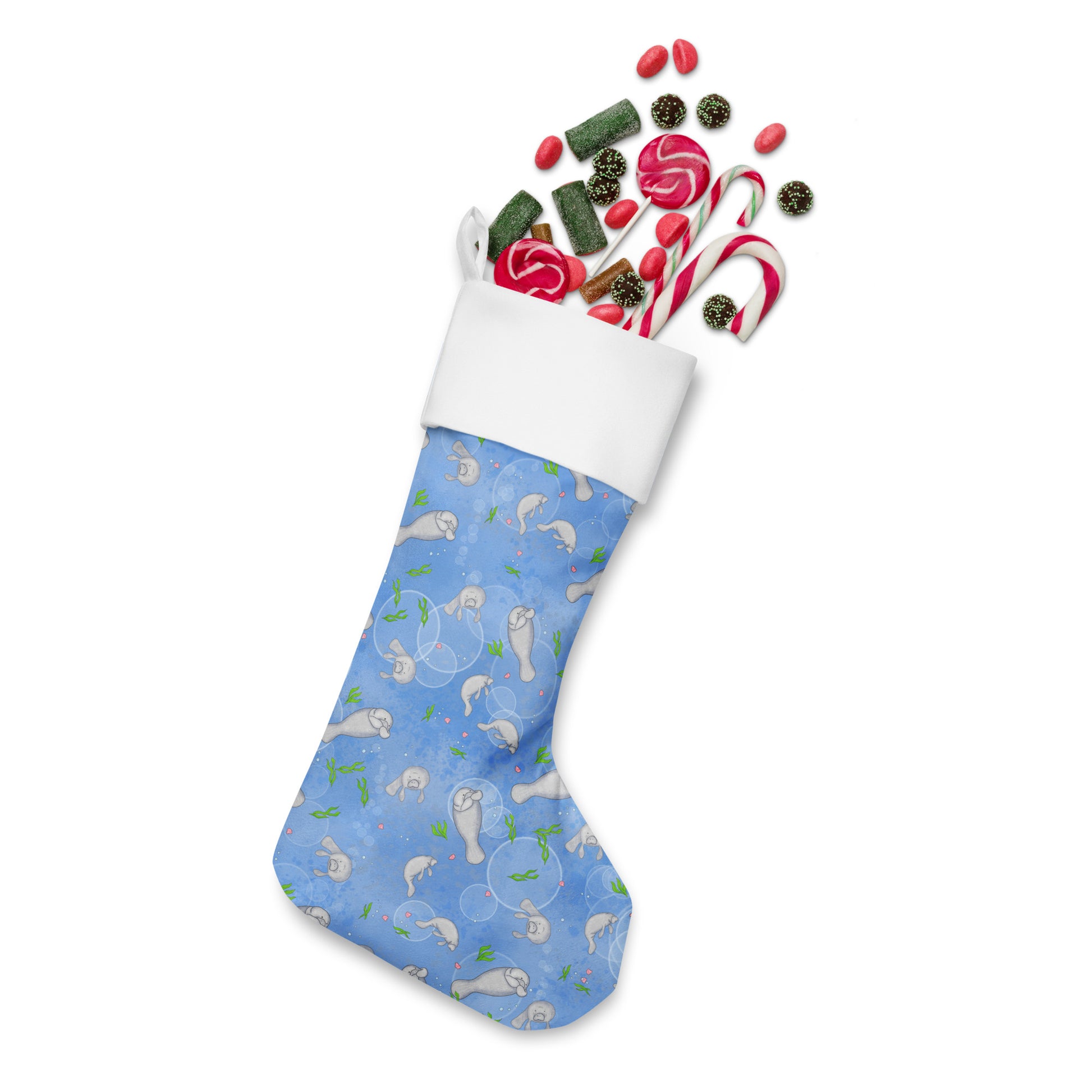 Limited Edition Manatee Christmas Stocking.  7 by 18 inches. The front has a hand-illustrated manatee design with an off-white polyester fabric on the back. It has a white fold-over cuff and a loop for hanging. Shown stuffed with candy.
