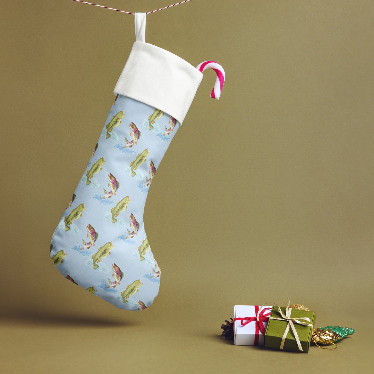 Limited Edition Blue Fishing Christmas Stocking.  7 by 18 inches. The front has watercolor rainbow trout and largemouth bass patterned on a blue background and an off-white polyester back fabric. It has a white fold-over cuff and a hanging loop. Shown hanging from a string.
