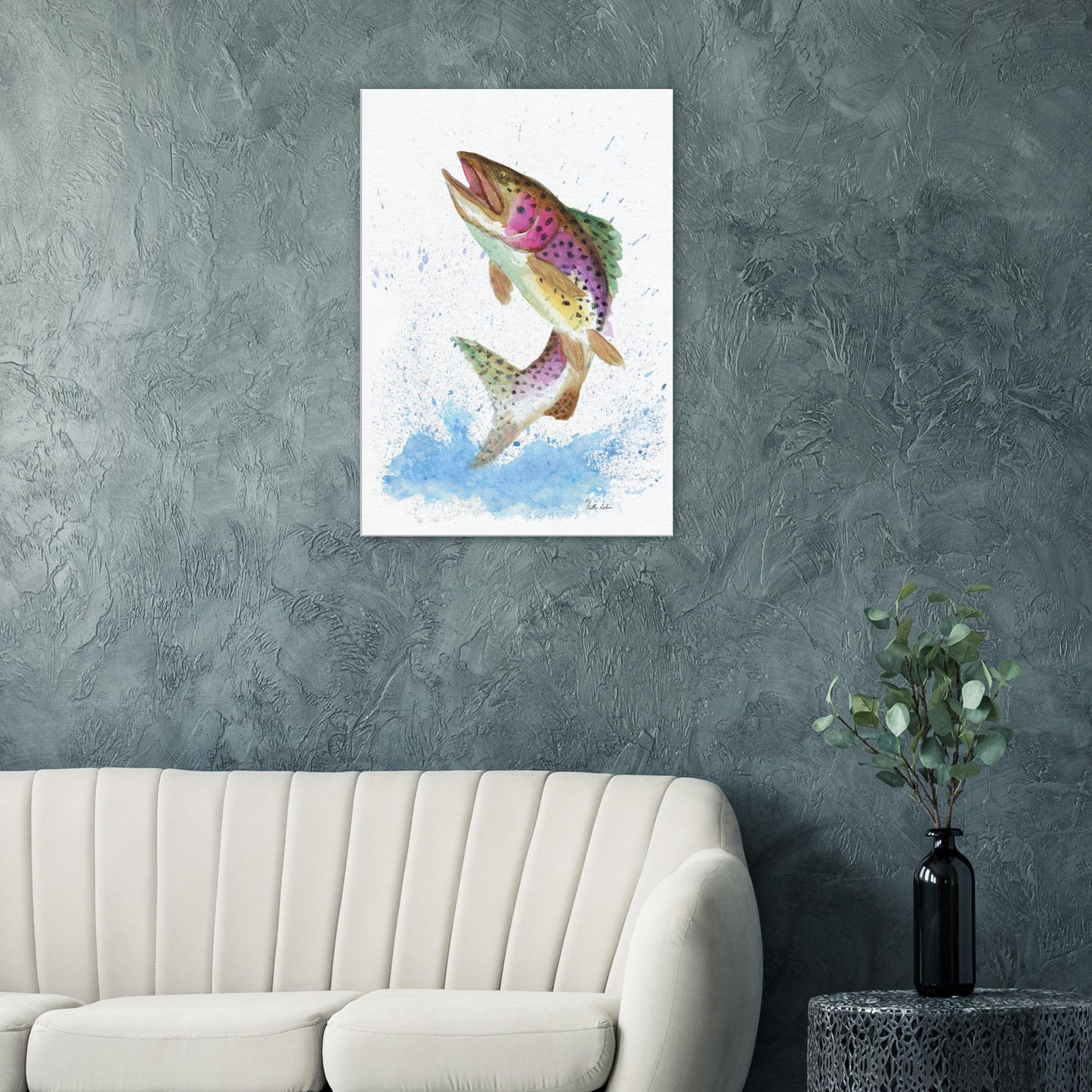 28 by 40 inch slim canvas wall art print featuring a watercolor painting of a rainbow trout leaping from the water. Shown on green wall above white sofa, end table and vase.