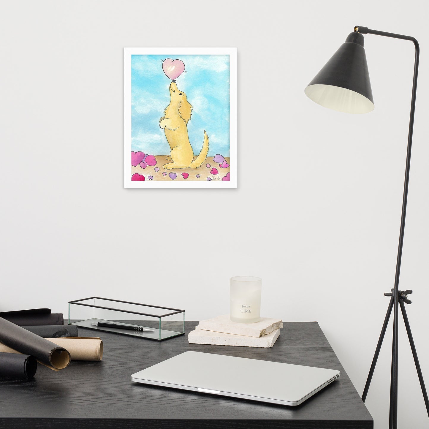 Framed watercolor art print entitled Puppy Love.  11 by 14 inch print in white ayous wood frame. Has acrylite cover to protect the art print. Hanging hardware included. Shown on wall above desk and lamp.