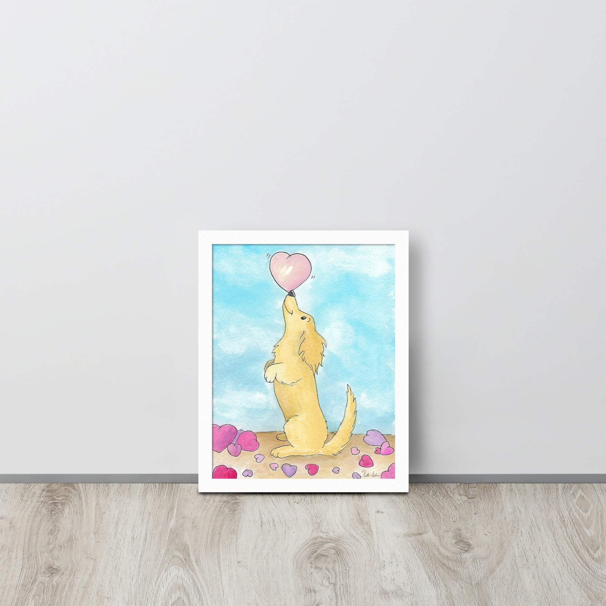 Framed watercolor art print entitled Puppy Love.  11 by 14 inch print in white ayous wood frame. Has acrylite cover to protect the art print. Hanging hardware included. Shown leaning against beige wall.