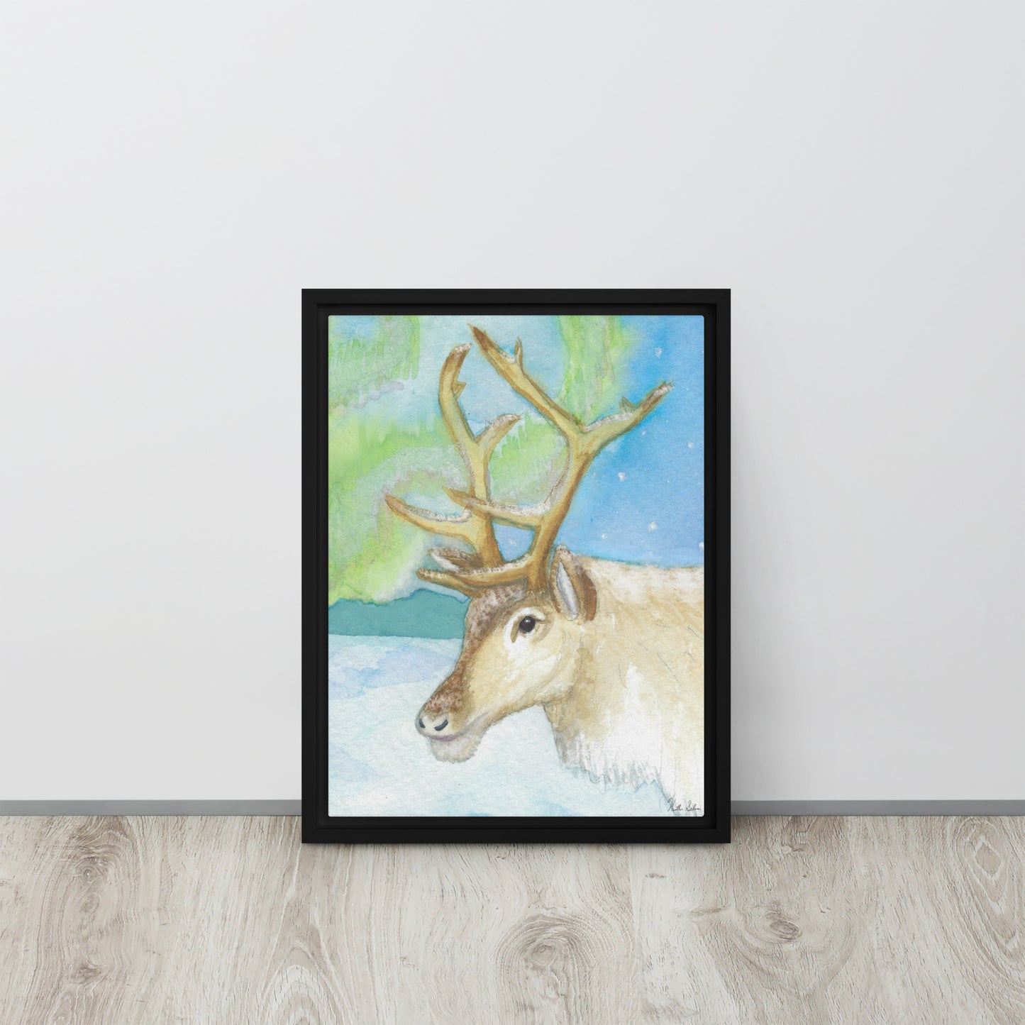 12 by 16 inch framed canvas art print of Heather Silver's Northern Lights Reindeer.  Canvas print mounted in a black pine frame. Shown leaning against wall.