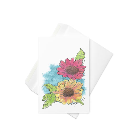 4 by 6 inch watercolor Gerber daisies greeting card and envelope. Has watercolor daisies on the front. The inside has a blue watercolor border with daisy accents and room for a message.