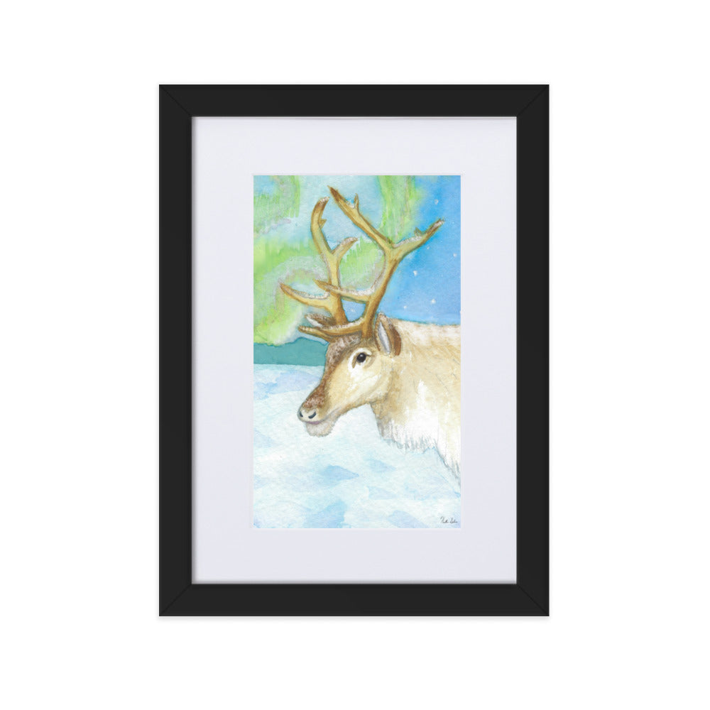 21 by 30 cm art print of a watercolor reindeer in the snow against the northern lights. Framed by a white mat and black ayous wood frame. Has acrylite cover and hanging hardware. Digitally signed by the artist, Heather Silver.