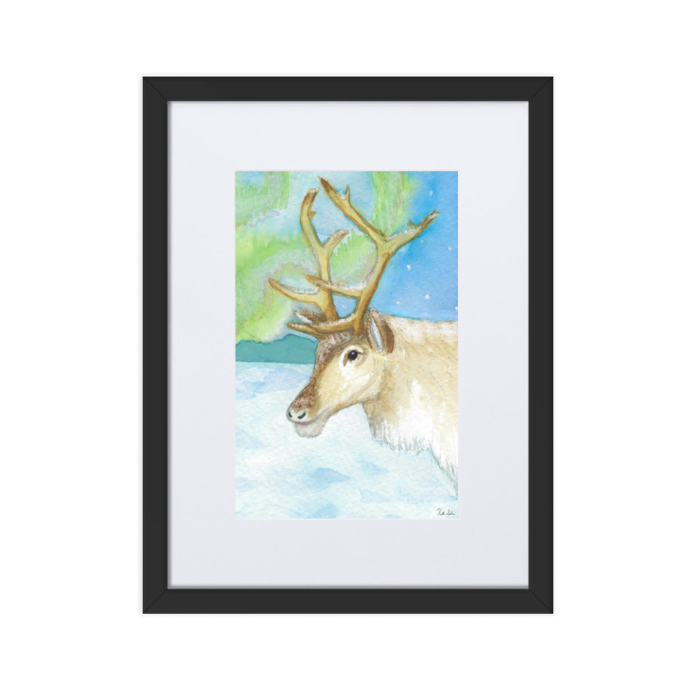 30 by 40 cm art print of a watercolor reindeer in the snow against the northern lights. Framed by a white mat and black ayous wood frame. Has acrylite cover and hanging hardware. Digitally signed by the artist, Heather Silver.