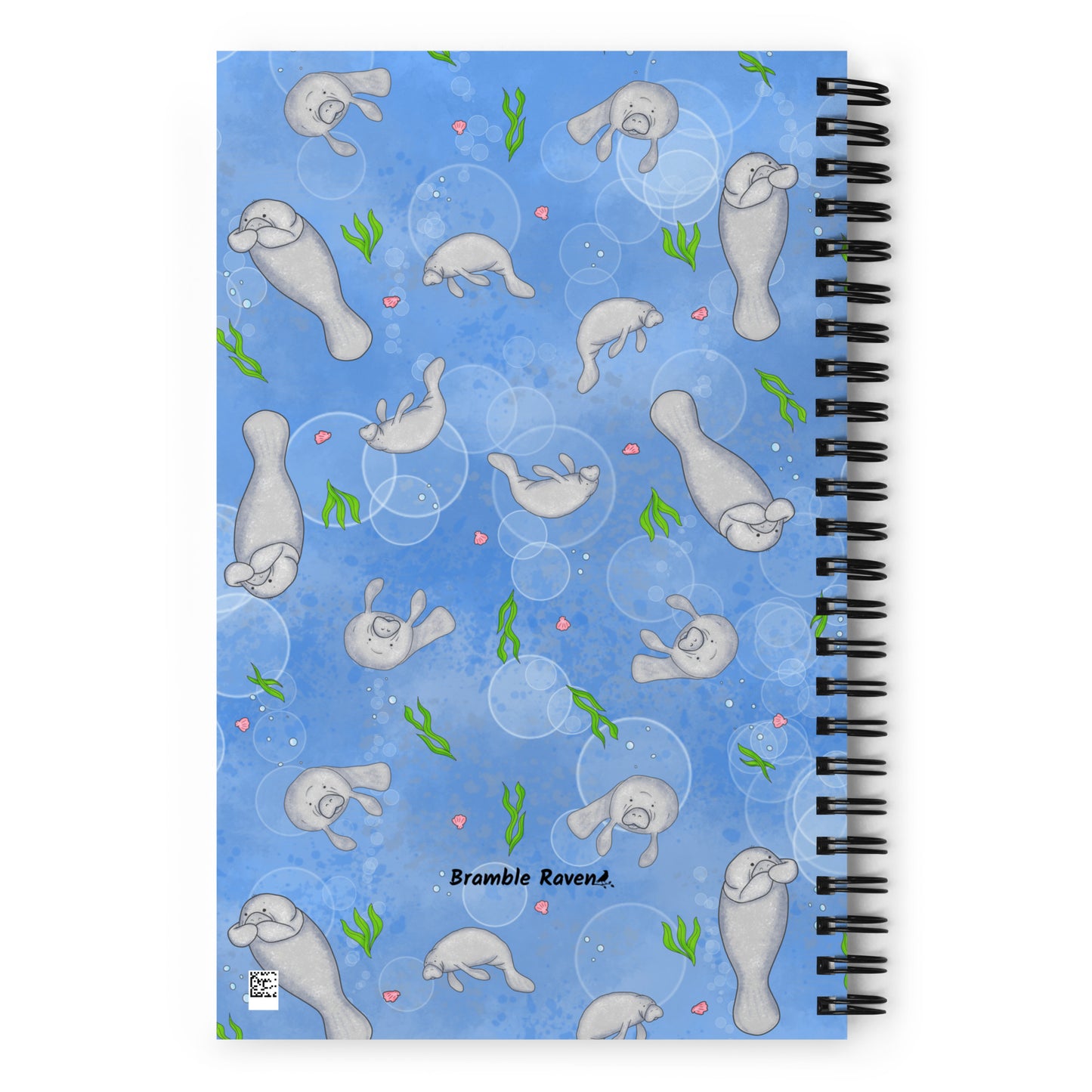 Spiral bound notebook with soft touch cover and 140 dotted pages. Cover features cute illustrated manatees swimming in the water. Measures 5.5 inches by 8.5 inches. Back view of notebook.