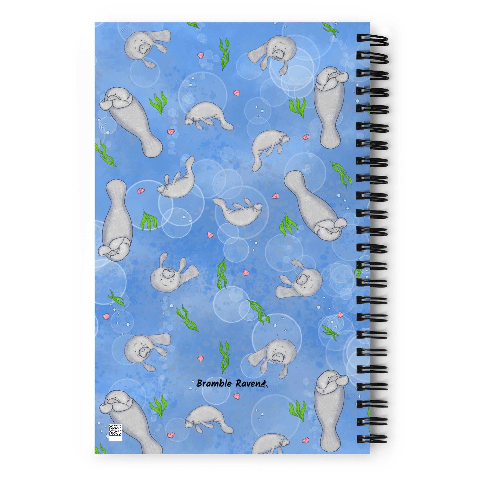 Spiral bound notebook with soft touch cover and 140 dotted pages. Cover features cute illustrated manatees swimming in the water. Measures 5.5 inches by 8.5 inches. Back view of notebook.