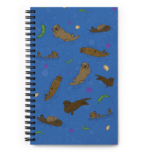 Spiral bound notebook with soft touch cover and 140 dotted pages. Cover features illustrated sea otters on a blue water background. Measures 5.5 inches by 8.5 inches.