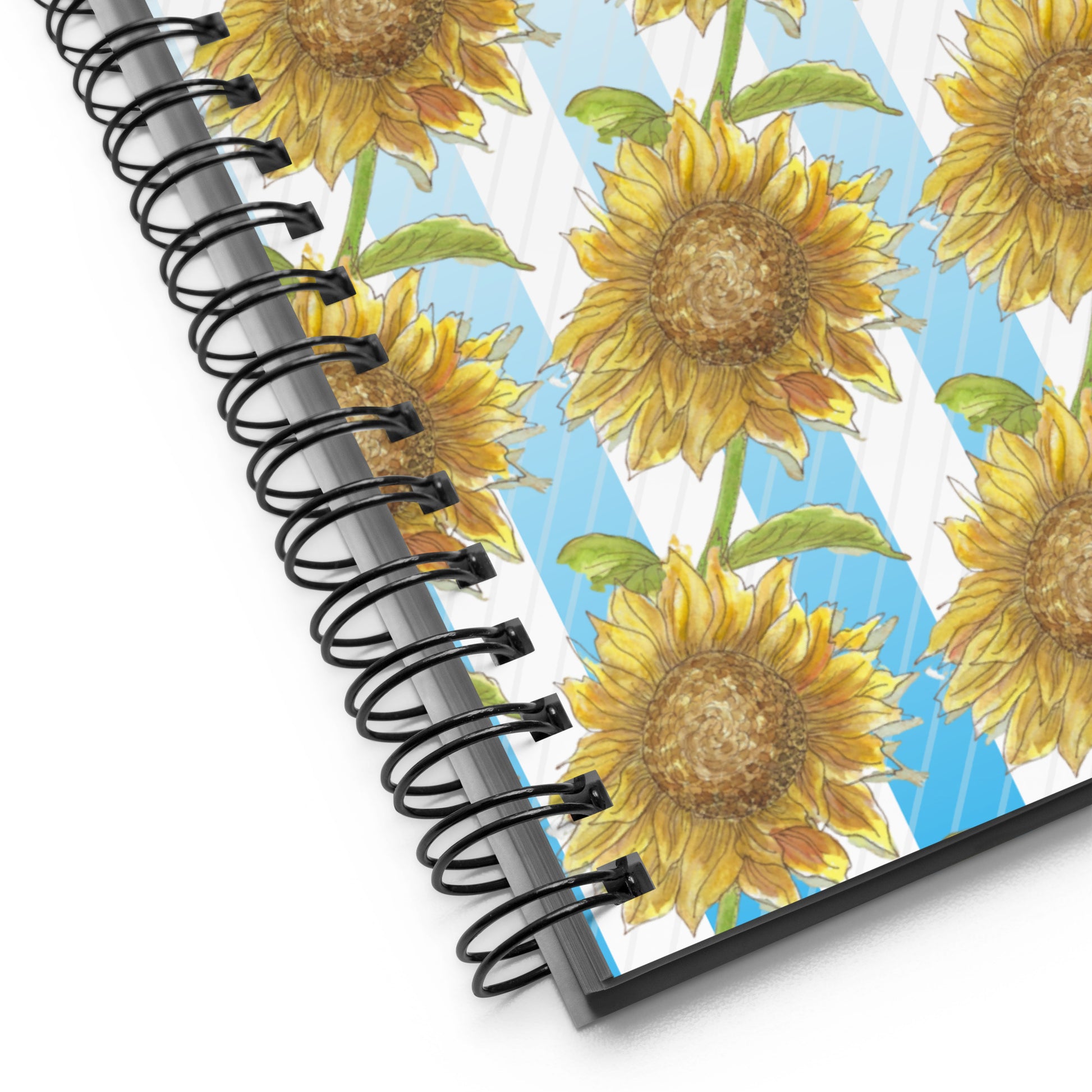 Spiral bound notebook with soft touch cover and 140 dotted pages. Cover features a pattern of watercolor sunflowers and blue and white stripes. Front has inspirational phrase "find your sunshine." Measures 5.5 inches by 8.5 inches. Detail view of metal spiral binding and cover image.