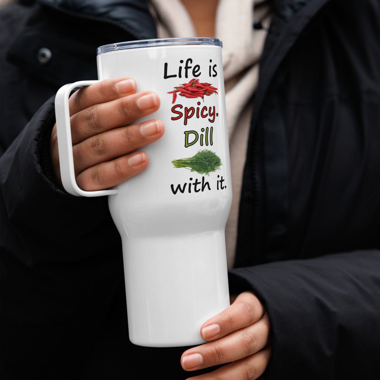 Stainless steel travel mug with handle. Holds 25 ounces of hot or cold liquids. Fits most car cup holders. Features double-sided phrase: Life is spicy. Dill with it, and accompanying chili pepper and dill weed images. Comes with spill proof plastic lid. Shown in model's hands.