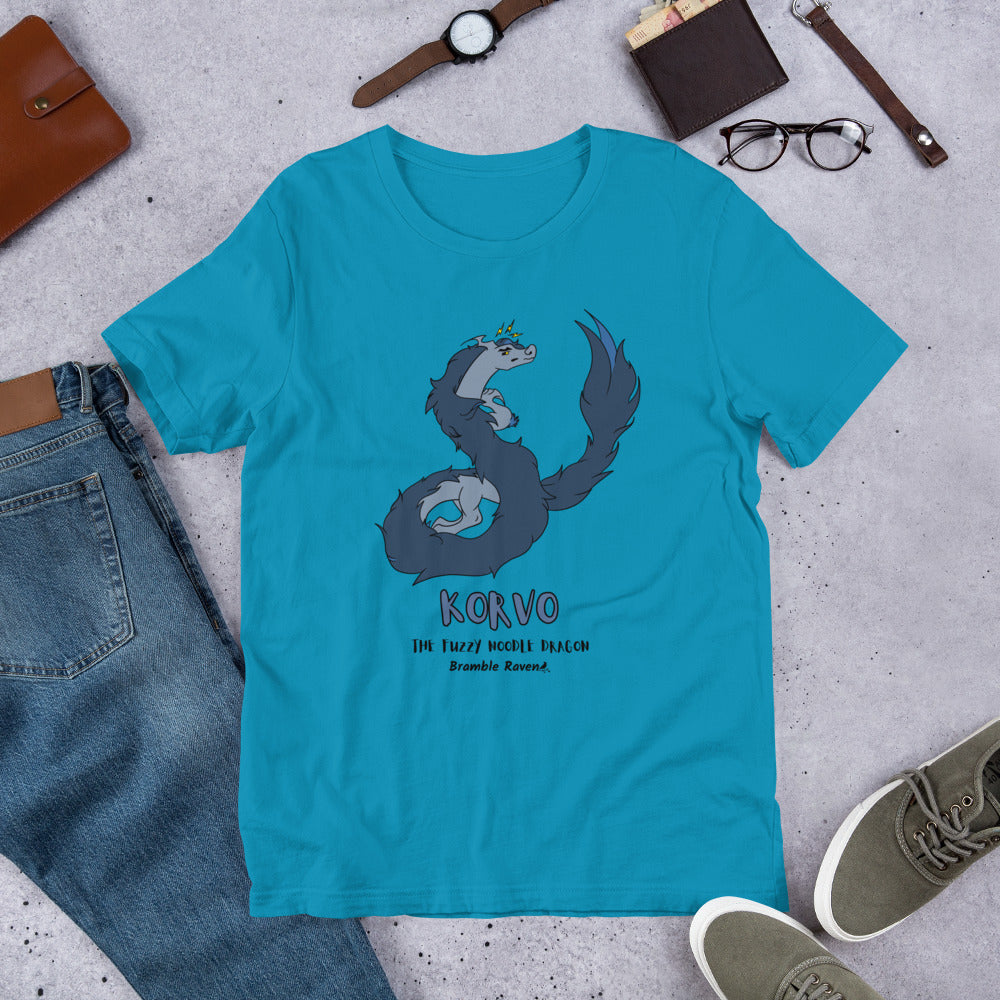 Korvo the angry Fuzzy Noodle Dragon on an aqua blue unisex t-shirt. Shown surrounded by pants, shoes, glasses, a watch, and wallet.
