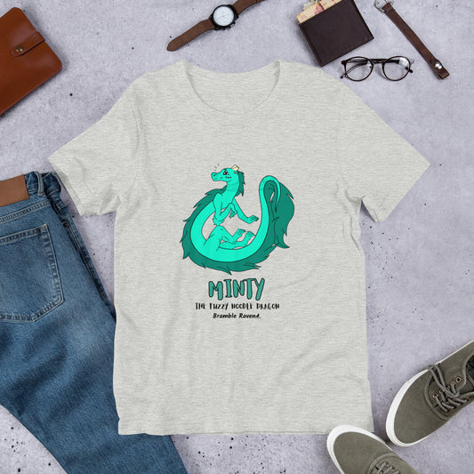 Minty the Fuzzy Noodle Dragon on an athletic heather grey unisex t-shirt. Shown surrounded by pants, shoes, glasses, a watch, and wallet.