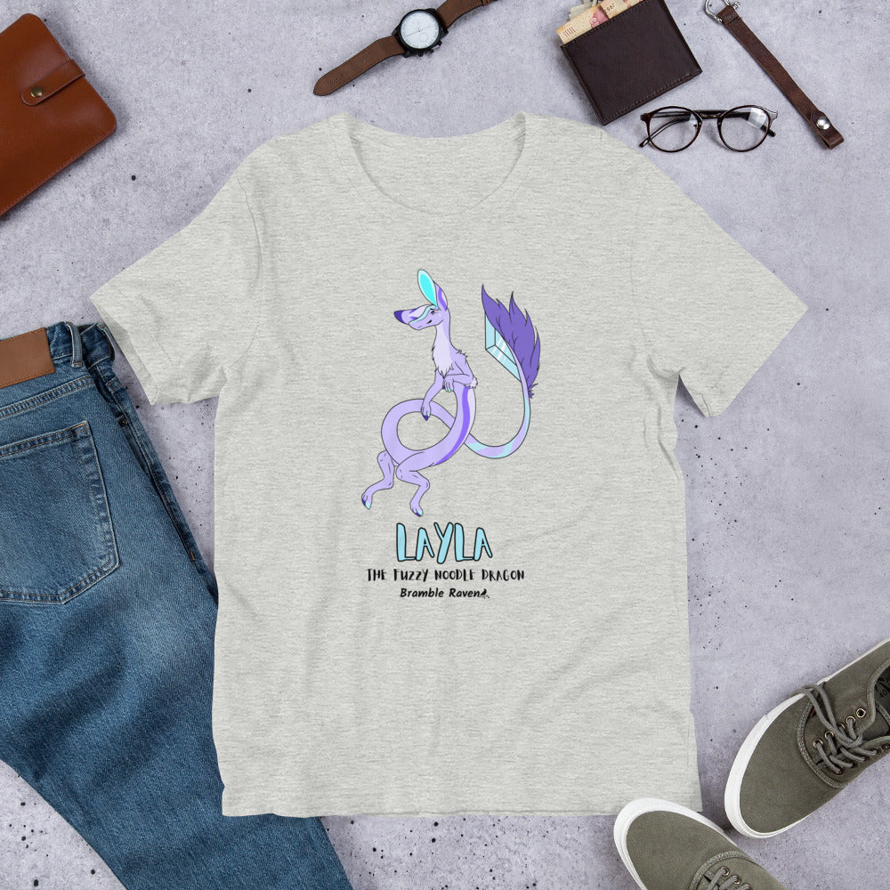Layla the Fuzzy Noodle Dragon on an athletic heather grey unisex t-shirt. Shown surrounded by pants, shoes, glasses, a watch, and wallet.