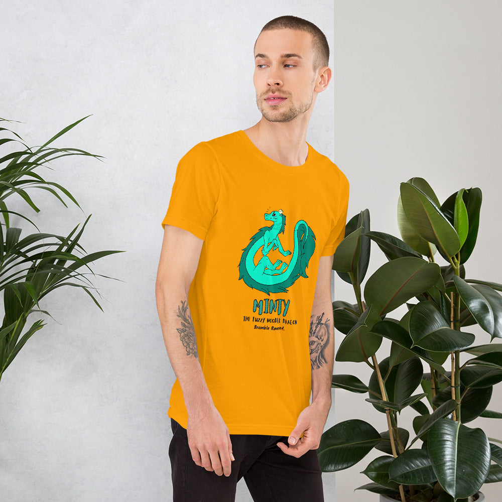 Minty the Fuzzy Noodle Dragon on a gold unisex t-shirt. Shown on a male model by some plants.