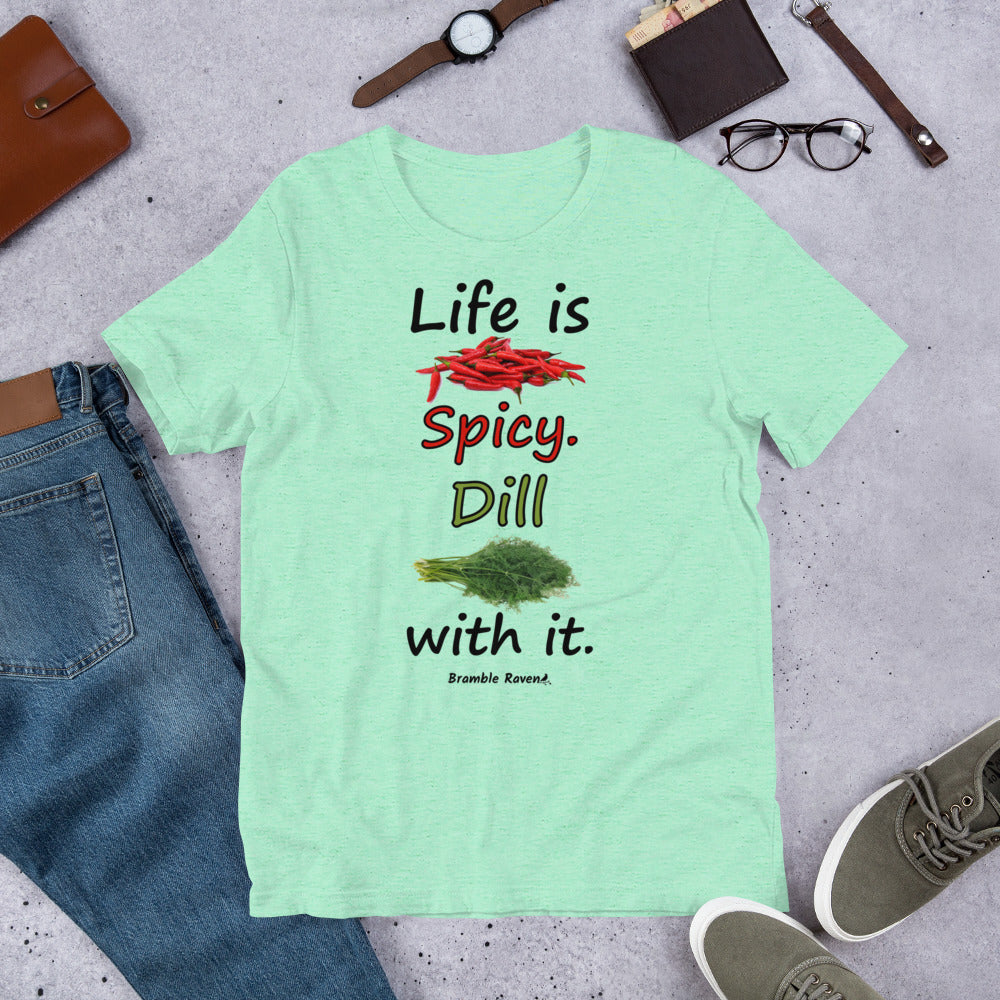 Heather mint colored unisex t-shirt. Features text: Life is Spicy. Dill with it. Graphic of chili peppers and dill weed. Made of preshrunk cotton with side seams. Shown on floor by pants, shoes, wallet and glasses.
