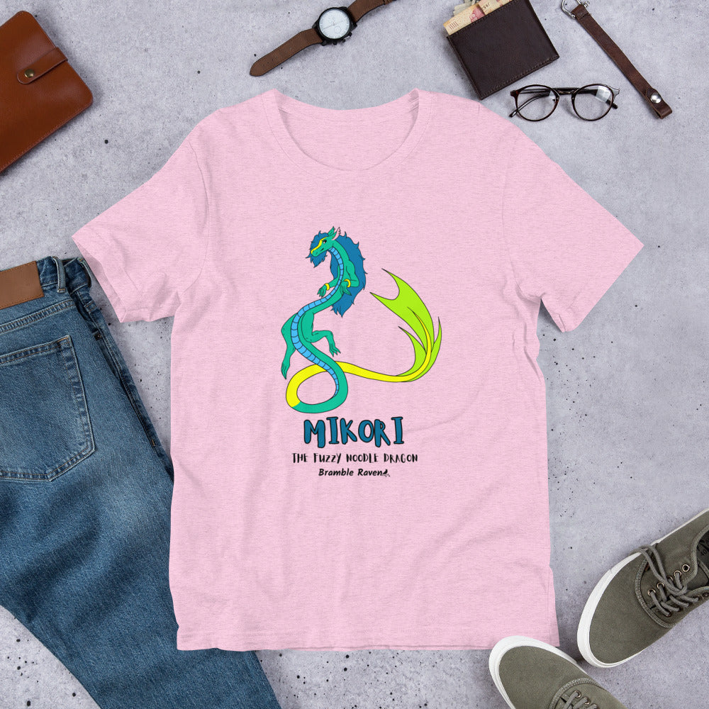 Mikori the Fuzzy Noodle Dragon on a heather prism lilac unisex t-shirt. Shown surrounded by pants, shoes, glasses, a watch, and wallet.