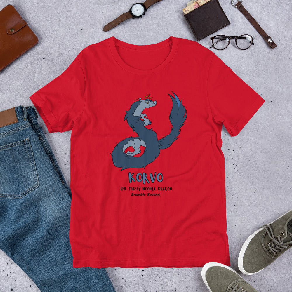 Korvo the angry Fuzzy Noodle Dragon on a red unisex t-shirt. Shown surrounded by pants, shoes, glasses, a watch, and wallet.