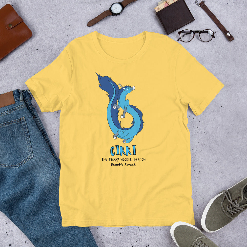 Cirri the Fuzzy Noodle Dragon on a yellow unisex t-shirt. Shown surrounded by pants, shoes, glasses, a watch, and wallet.