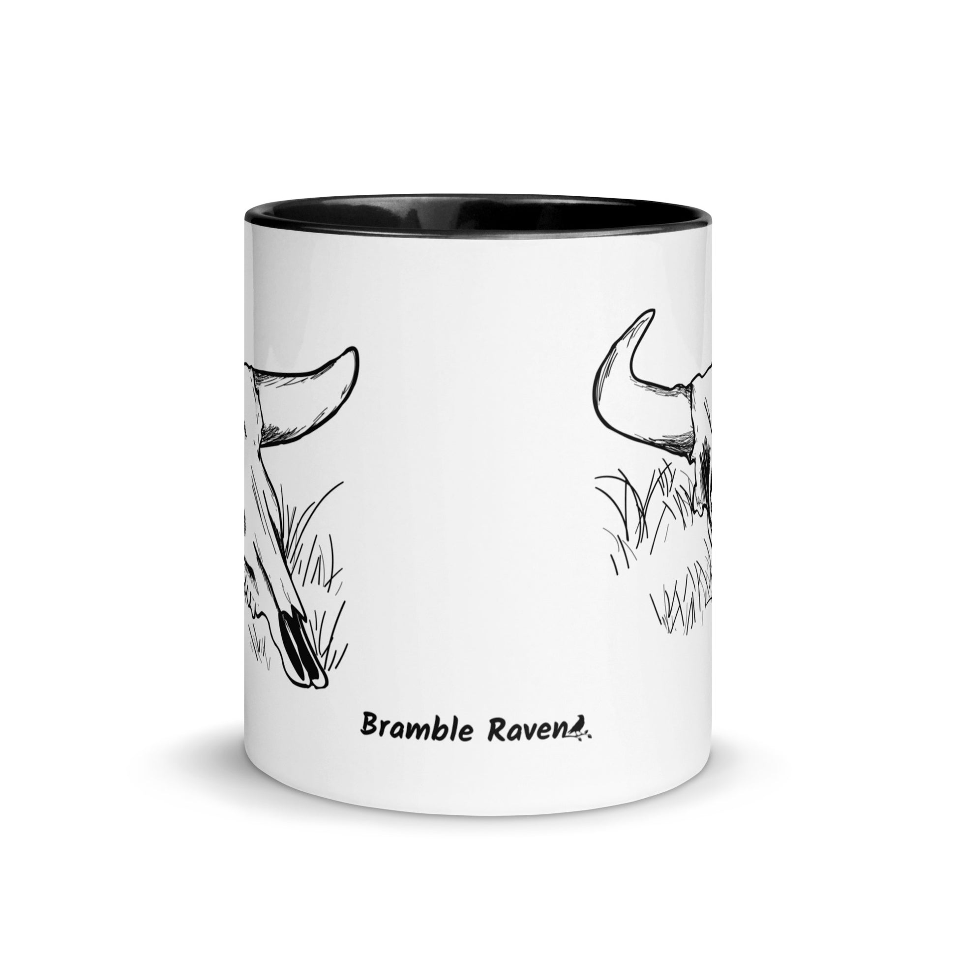 11 ounce ceramic mug. White with black handle and inside. Features double sided image of a cow skull cradling a bird nest. Front view.