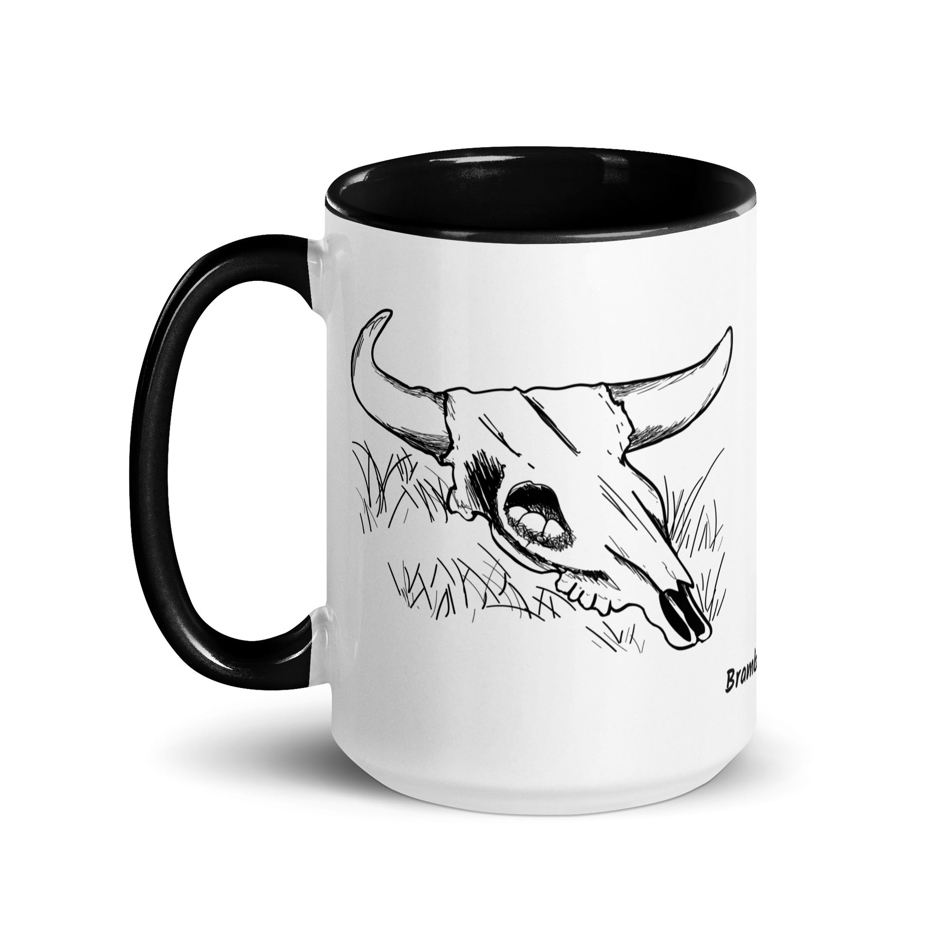 15 ounce ceramic mug. White with black handle and inside. Features double sided image of a cow skull cradling a bird nest.
