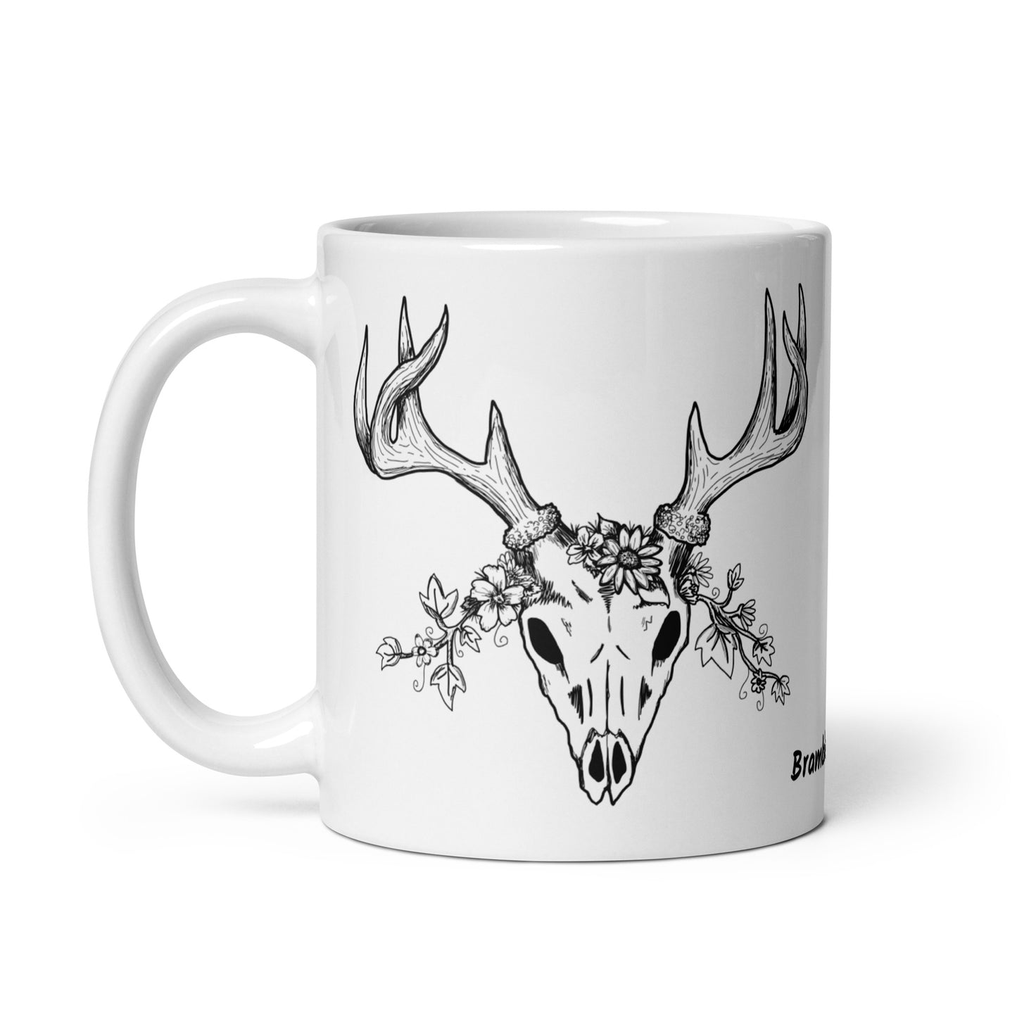 11 oz white ceramic mug. Features a double-sided hand illustrated image of a deer skull wreathed in flowers.