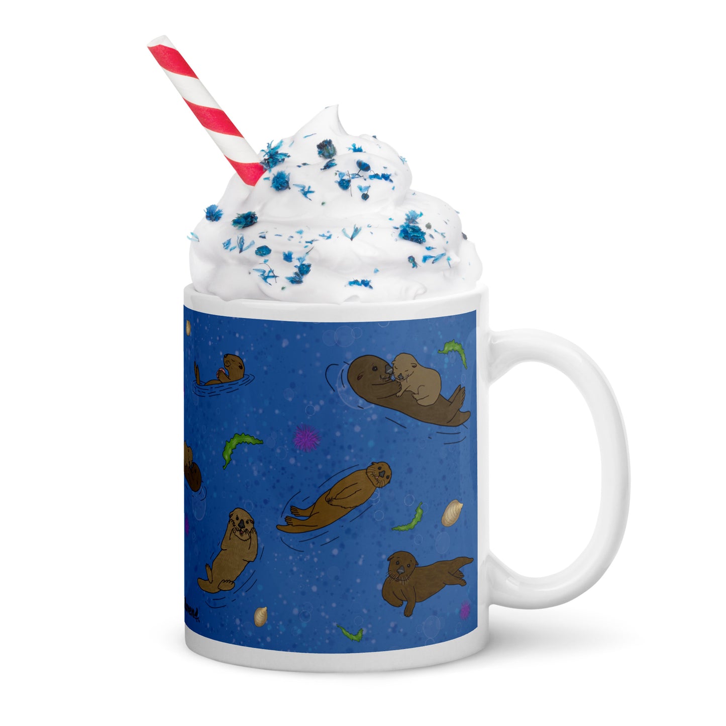 11 ounce white ceramic mug with sea otters on an ocean blue background. Mug is microwave and dishwasher safe. Shown with whipped cream, sprinkles, and a straw.