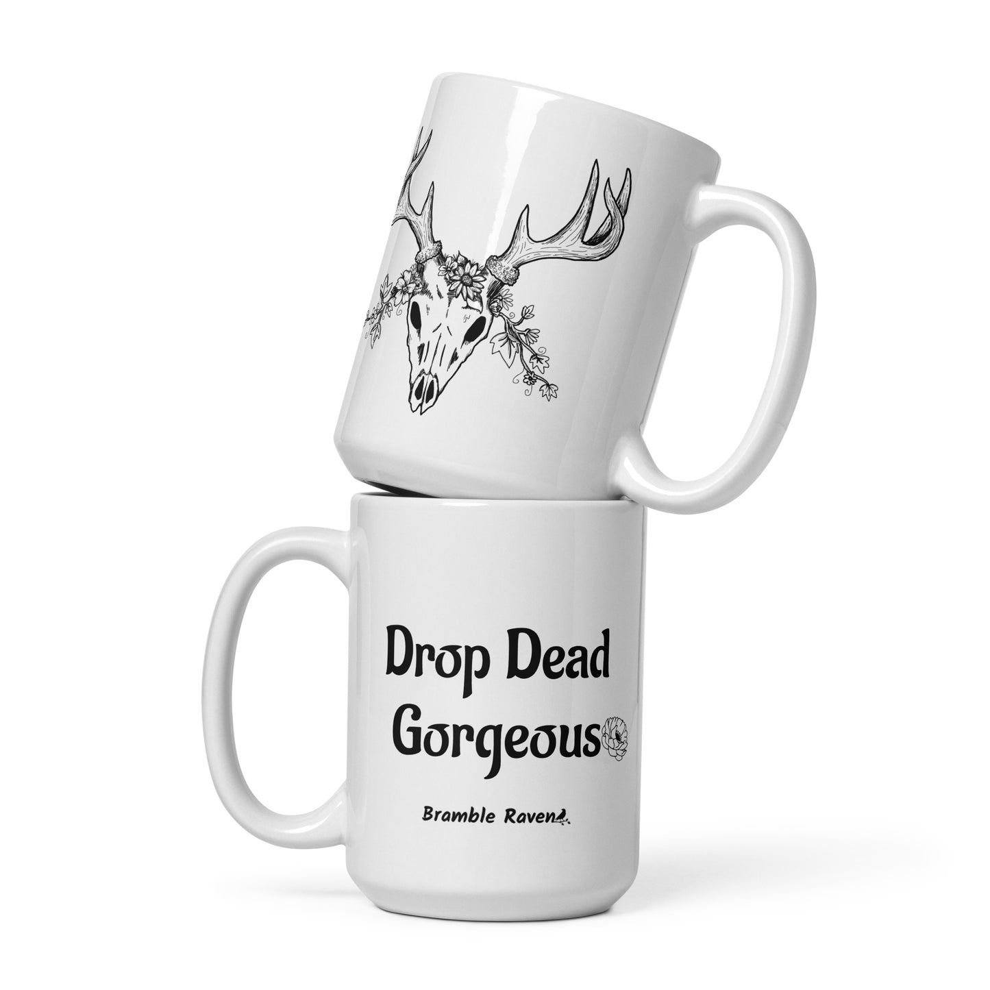 15 ounce white ceramic mug. Features illustrated deer skull wreathed in flowers on one side and Drop dead gorgeous text on the other side. Dishwasher and microwave safe.