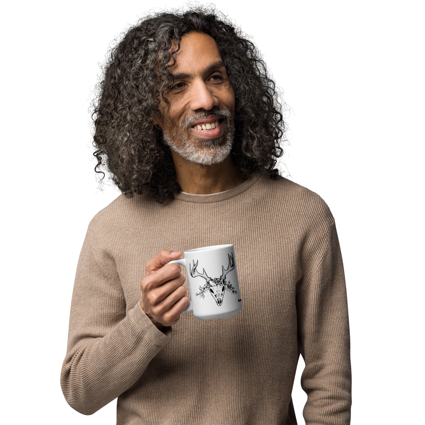15 oz white ceramic mug. Features a double-sided hand illustrated image of a deer skull wreathed in flowers. Shown being held in male model's hand.