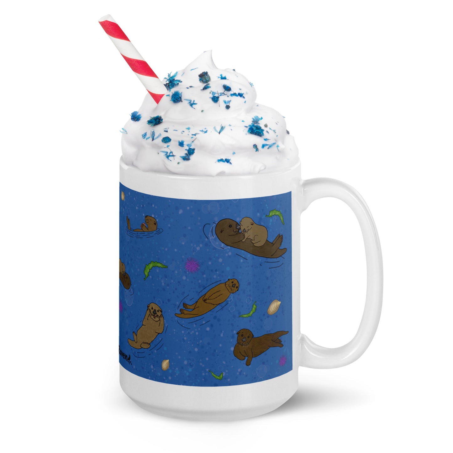 15 ounce white ceramic mug with sea otters on an ocean blue background. Mug is microwave and dishwasher safe. Shown with whipped cream, sprinkles, and a straw.