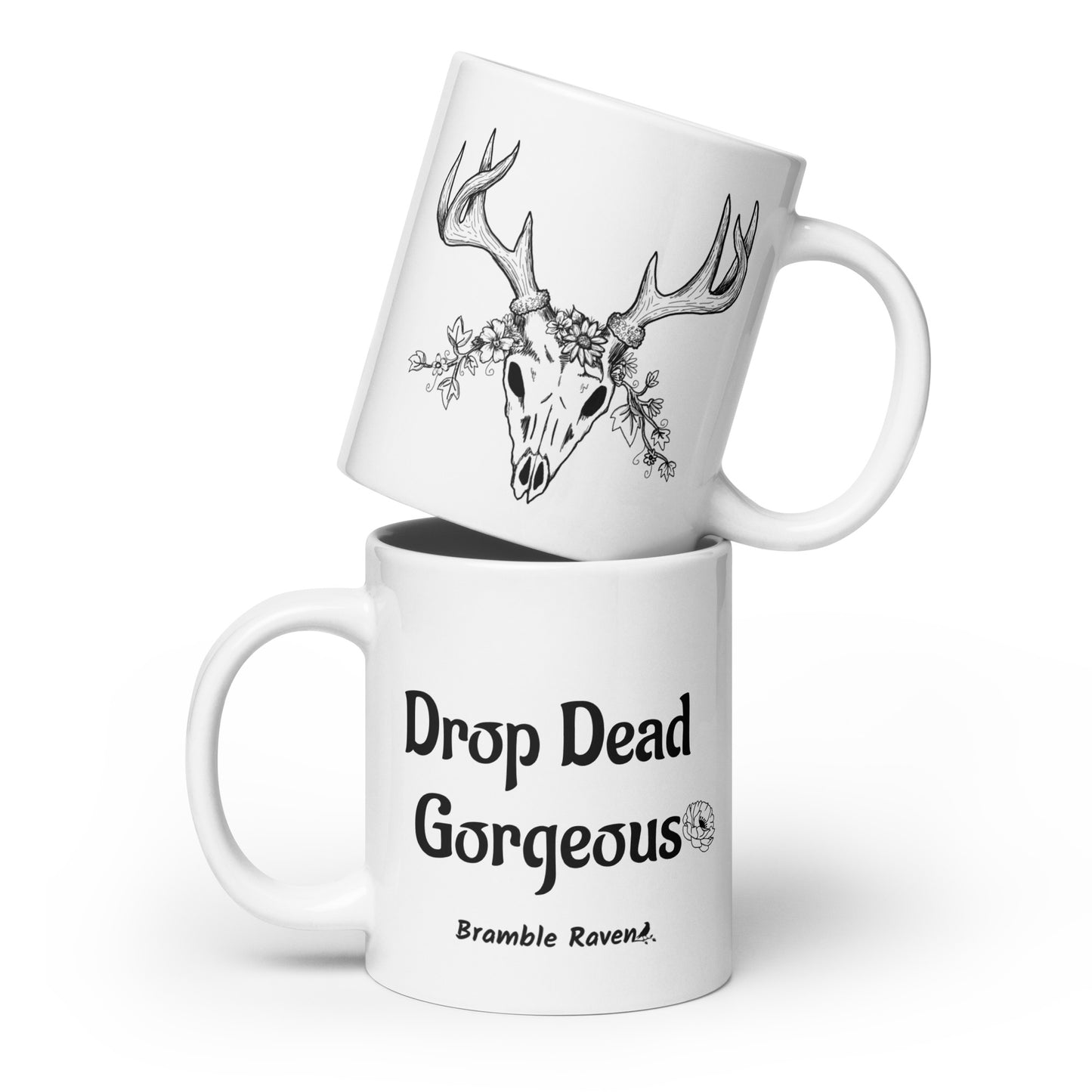 20 ounce white ceramic mug. Features illustrated deer skull wreathed in flowers on one side and Drop dead gorgeous text on the other side. Dishwasher and microwave safe.