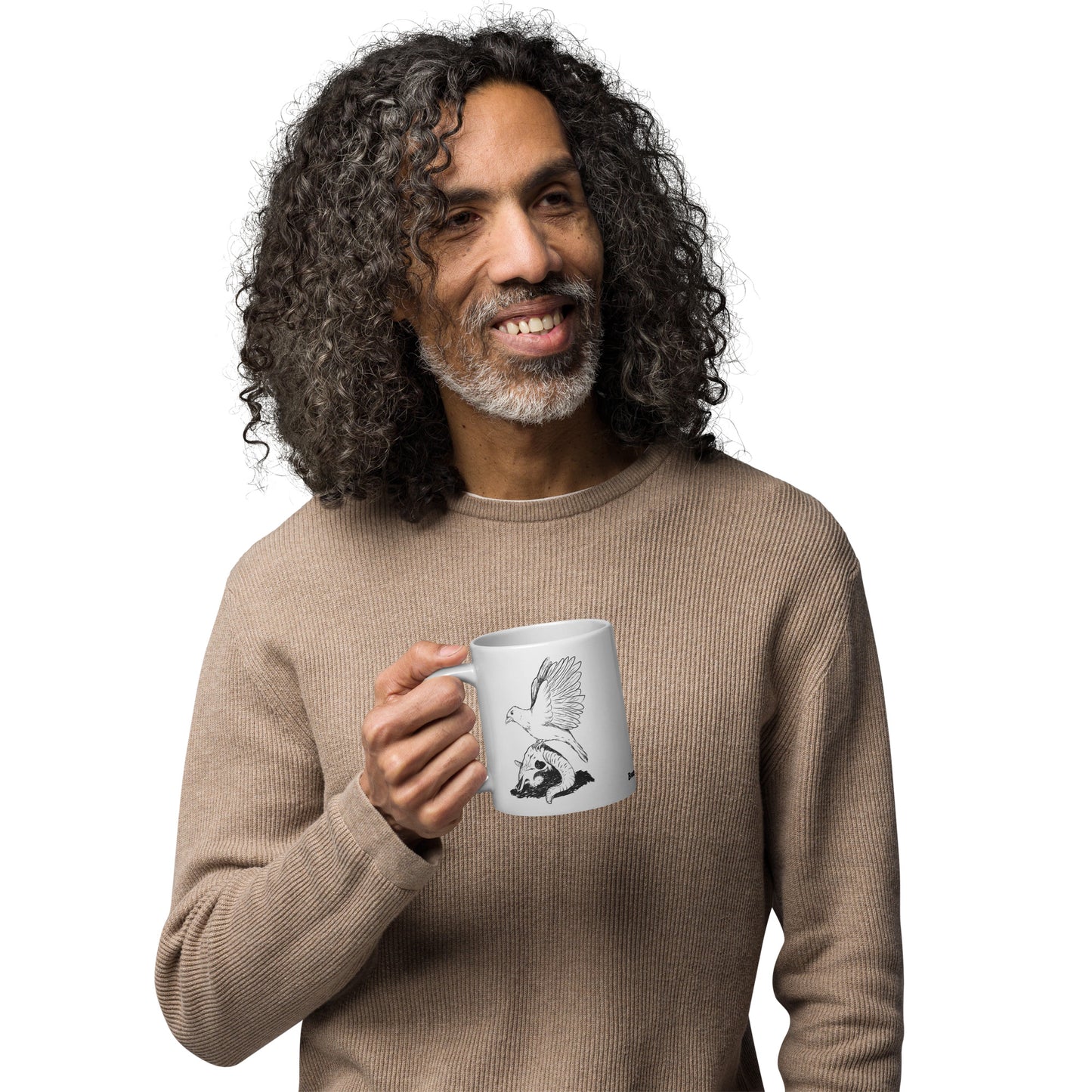20 ounce white glossy mug featuring double sided print of Reflections, a design with a crow with wings outstretched on a sheep skull. Shown in male model's hands.