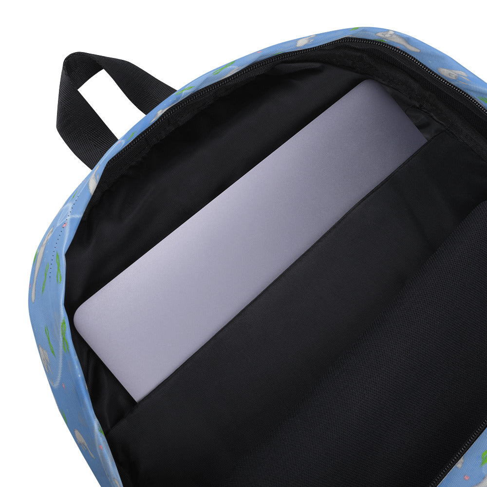 Medium-sized backpack featuring manatees, seashells, seaweed and bubbles on a blue background. Made with water resistant polyester, ergonomic straps, and comfort mesh back. Has a compartment that can hold a 15 inch laptop. Has a hidden zipper pocket on the back. Detail image shows compartment for 15 inch laptop.