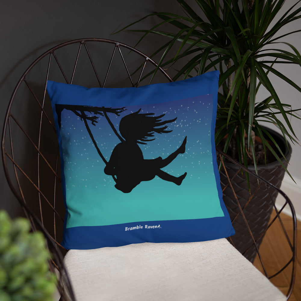 Original Swing Free design of a girl's silhouette in a tree swing against the backdrop of a blue starry sky. Rectangular image on front of pillow with blue background fabric. Pillow has design on both sides. 18 by 18inch accent pillow. Shown on wicker chair.