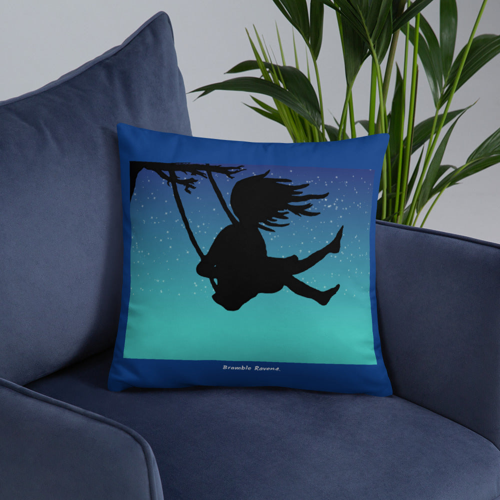 Original Swing Free design of a girl's silhouette in a tree swing against the backdrop of a blue starry sky. Rectangular image on front of pillow with blue background fabric. Pillow has design on both sides. 18 by 18 inch accent pillow. Shown on blue sofa.