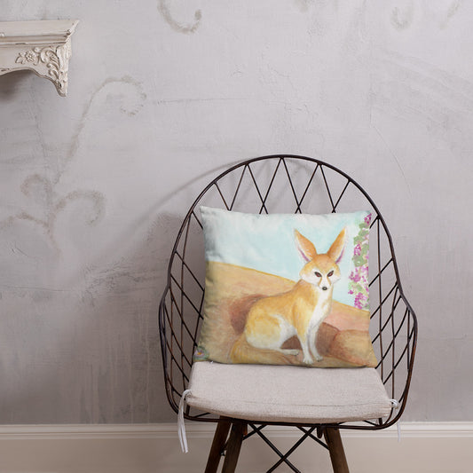 18 by 18 inch accent pillow. Features original watercolor painting of a fennec fox in the desert. Double-sided pillow with print on both sides. Shown on a wicker chair.